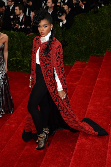 Janelle Monae in a red and black Tadashi Shoji cape and Jimmy Choo sandals at the 2014 Met Gala.