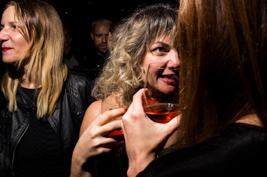 A curly blonde woman talking to someone intensely at W's Golden Globes party 