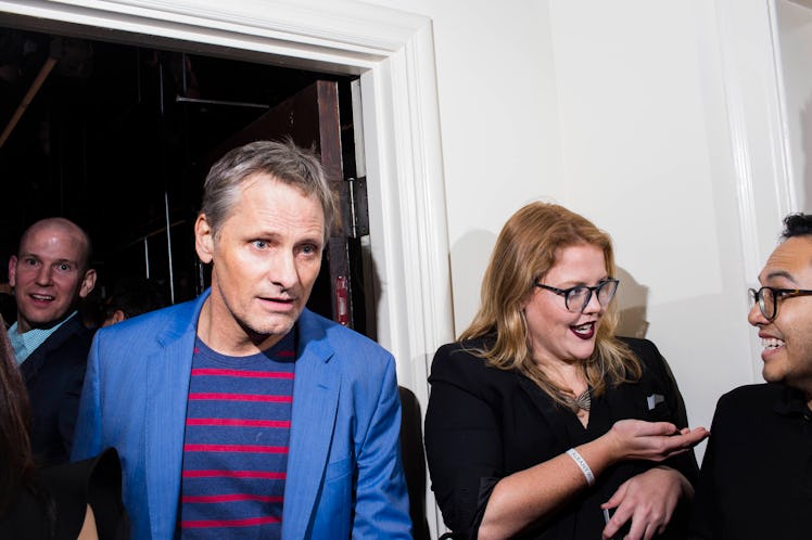 Viggo Mortensen in a blue blazer and red and blue striped sweater walking out of the W party 