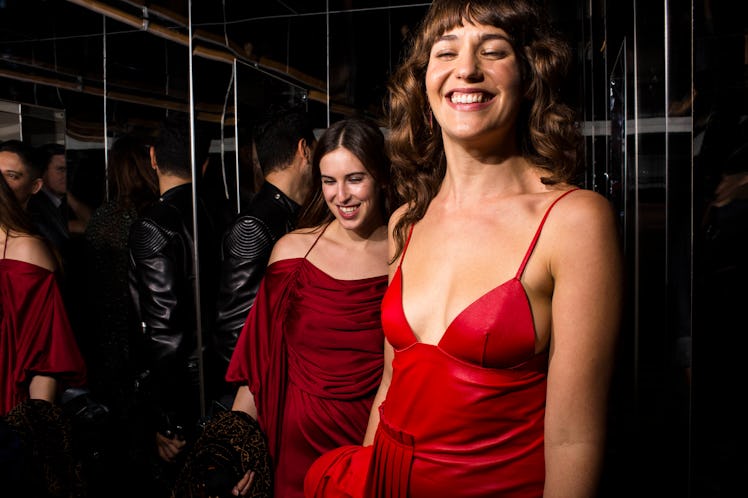 Two women in red dresses laughing as they walk through W's Golden Globes party 