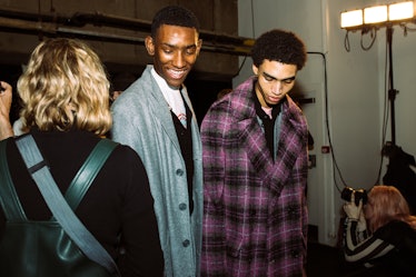 Two male models wearing grey and purple coats