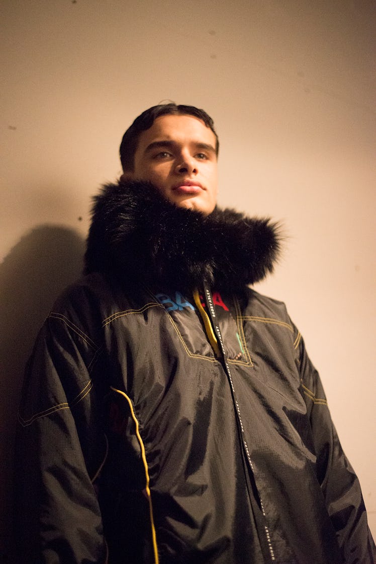 A male model wearing parka with a black fur collar at London Fashion Week
