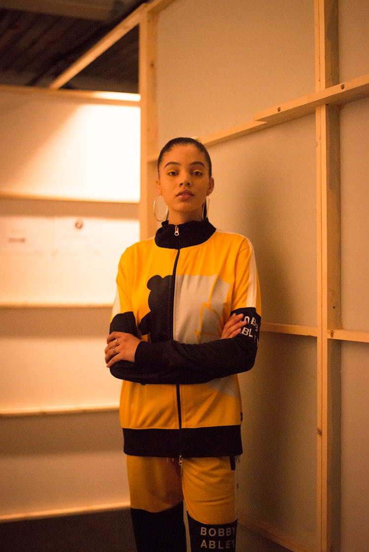 A model in Bobby Abley yellow tracksuit backstage at London Fashion Week