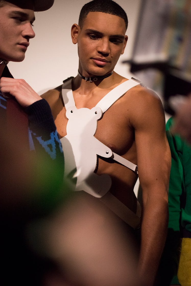 A male model wearing a white harness and a choker necklace at London Fashion Week