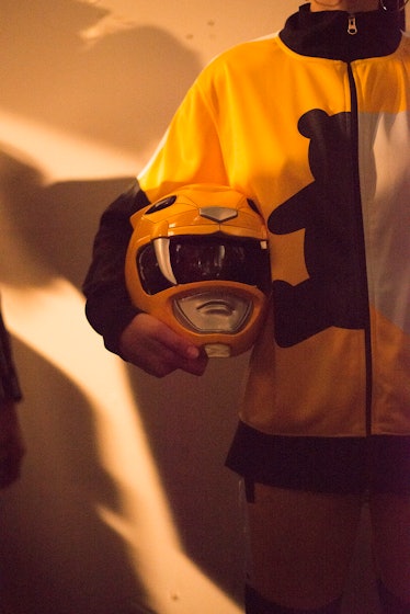 A model holding a Power Rangers inspired helmet backstage at London Fashion Week