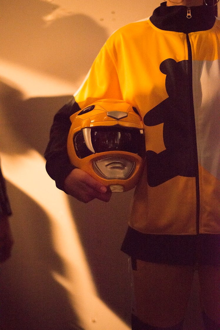 A model holding a Power Rangers inspired helmet backstage at London Fashion Week
