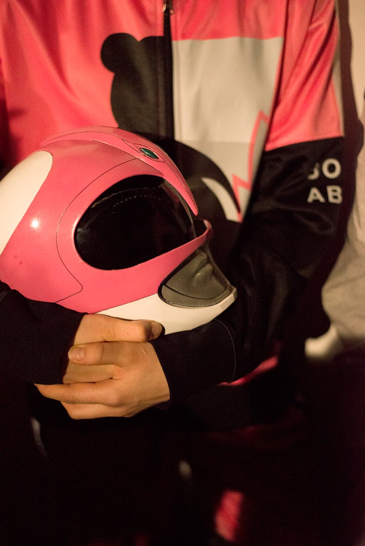 A model in a pink Bobby Abley tracksuit holding a pink Power Ranger helmet