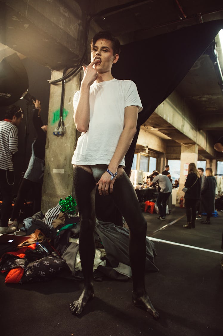 A model holding his index finger on his teeth at Charles Jeffrey’s MAN Fall 2017 presentation