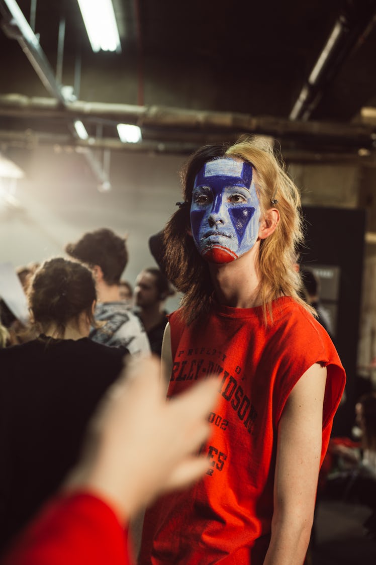 A model wearing a red sleeveless shirt at Charles Jeffrey’s MAN Fall 2017 presentation