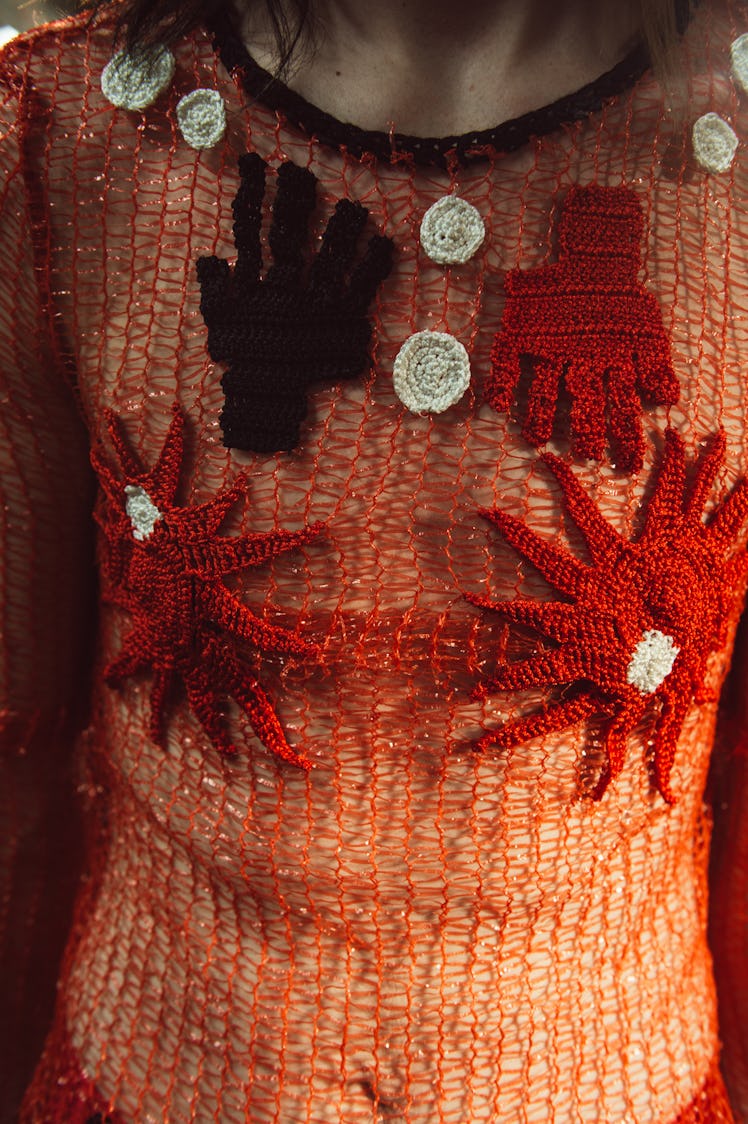 A model wearing a red netted see-through blouse