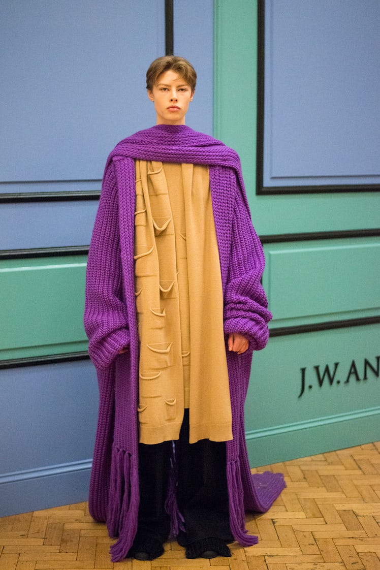 A model posing backstage in a purple knit coat from J.W. Anderson’s Fall/Winter 2017 Collection.