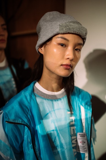 A model wearing a grey knit beanie and a blue jacket from Christopher Ræburn’s Fall/Winter 2017 Coll...