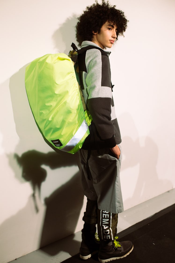 A model carrying a neon sustainable backpack from Christopher Ræburn’s Fall/Winter 2017 Collection.