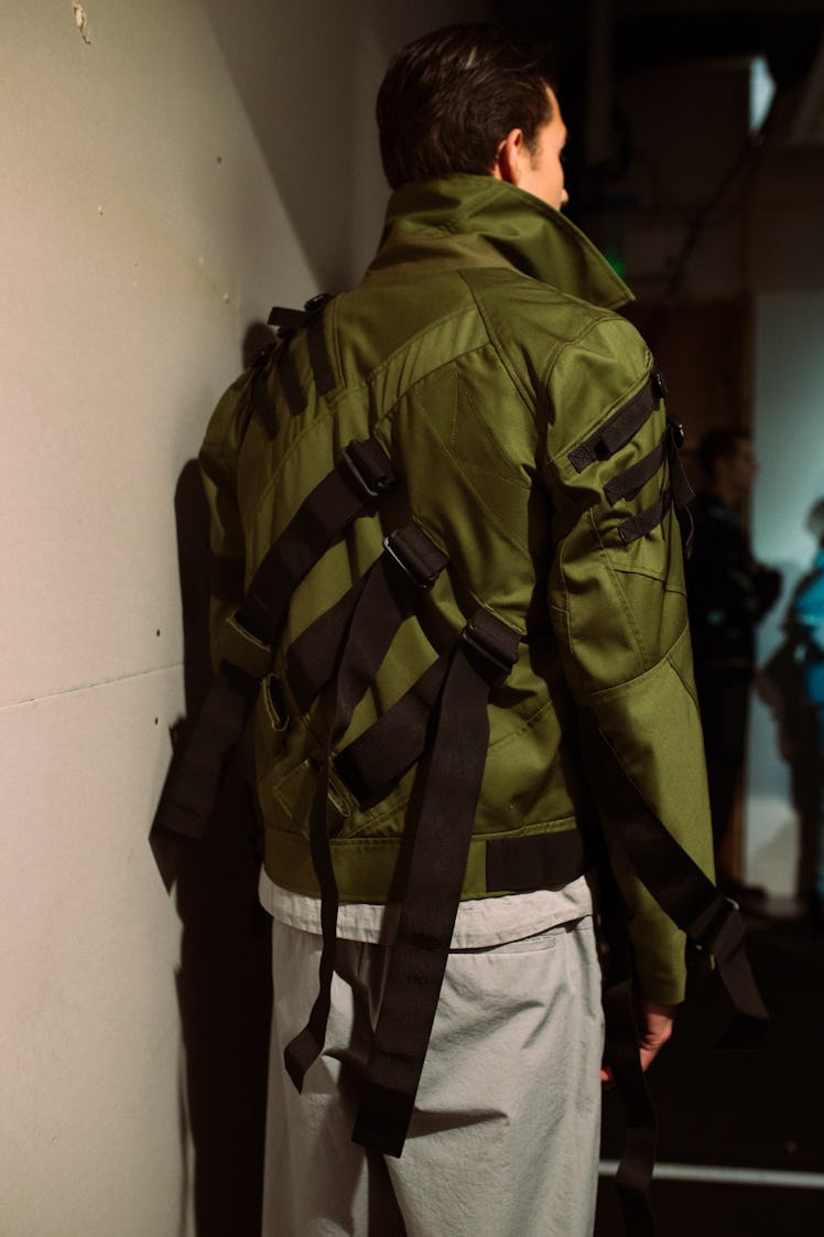 A model wearing a green jacket by London Men’s Designer Christopher Ræburn