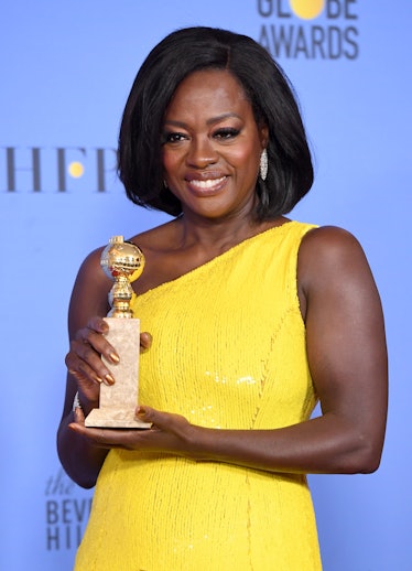 Viola Davis wearing a yellow dress and Harry Winston earrings on the Golden Globes Red Carpet.