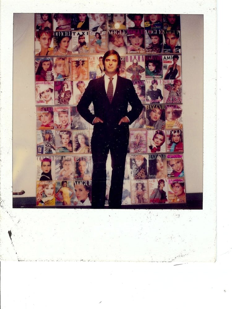 John Casablancas standing in front of magazine covers where his models were featured