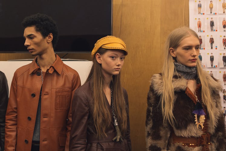 Three models in brown and camel outfits standing backstage at the Fall 2017 Prada Fashion Show