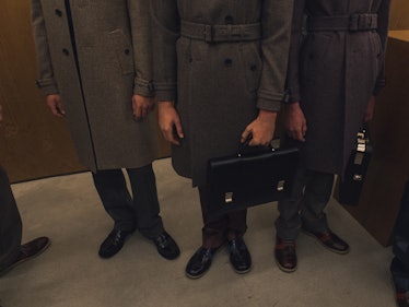 Three model in grey coats standing backstage at the Fall 2017 Prada Fashion Show