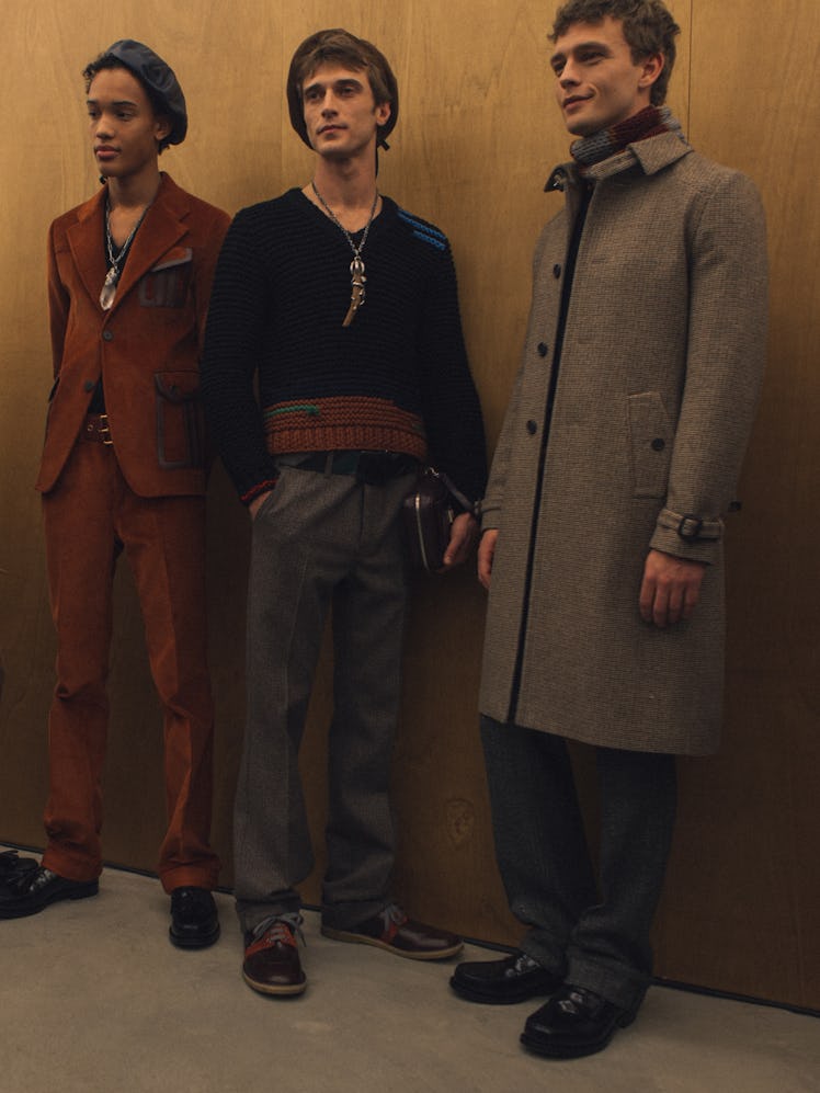 Three models in full outfits posing backstage at the Fall 2017 Prada Fashion Show