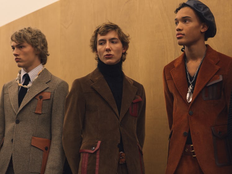 Three models in a brown, camel and beige coat posing backstage at the Fall 2017 Prada Fashion Show