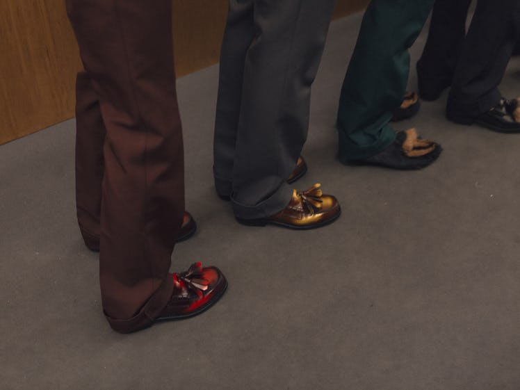 A close-up portrait of four pairs of model legs backstage at the Fall 2017 Prada Fashion Show