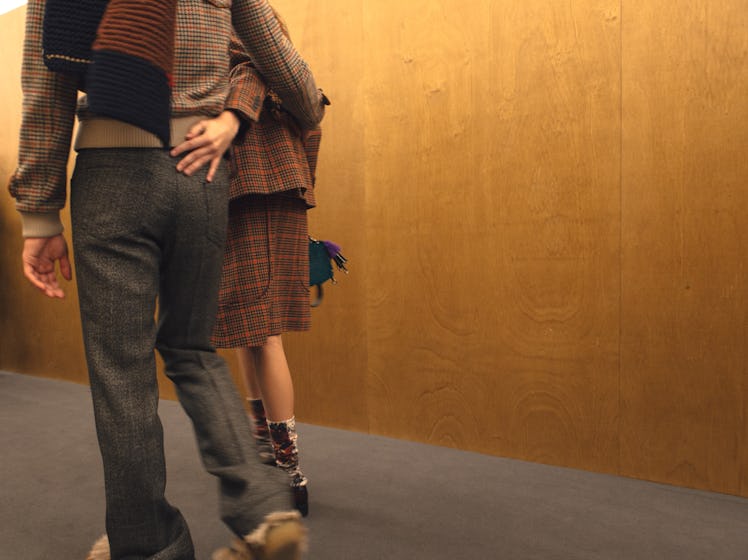 Two models hugging and walking backstage at the Fall 2017 Prada Fashion Show