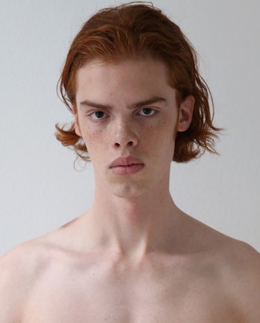 Male model, Noah Aamund. with red hair, shirtless, while posing for a photo.