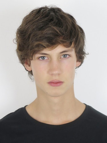 Male model, Tom Boitaud, wearing a black t-shirt while posing for a photo.