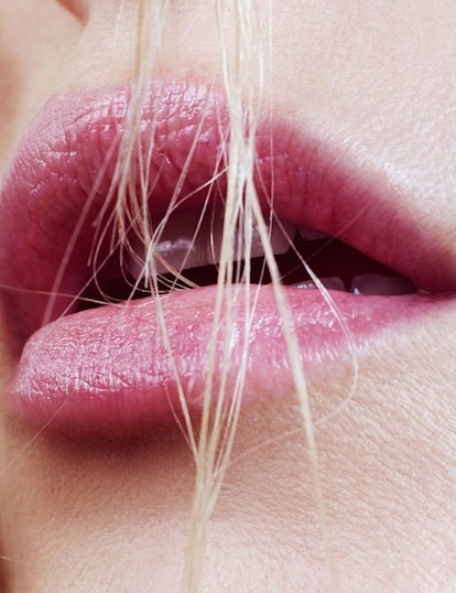 Close-up of lips of a blonde woman with her hair falling over