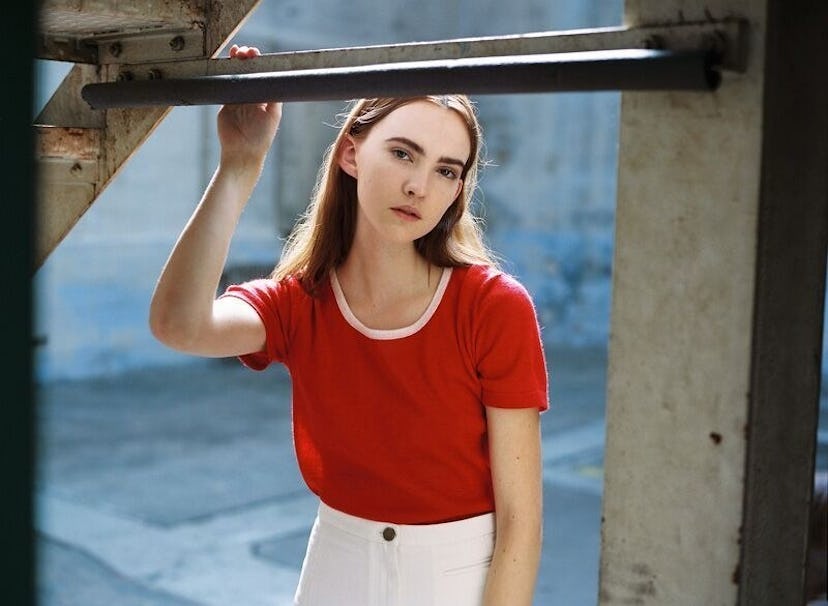 A model wearing a red t-shirt and white pants from the Hesperios Spring Summer 2017 collection