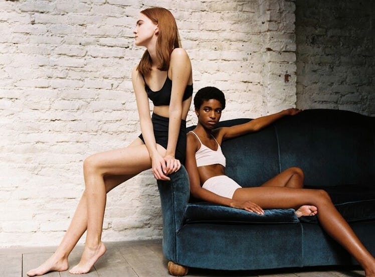 Two models, one wearing black and the other wearing a white bra and shorts from the Hesperios Spring...
