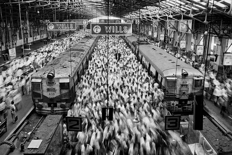 A large blurred crowd around two trains at the Church Gate Station, Bombay, India