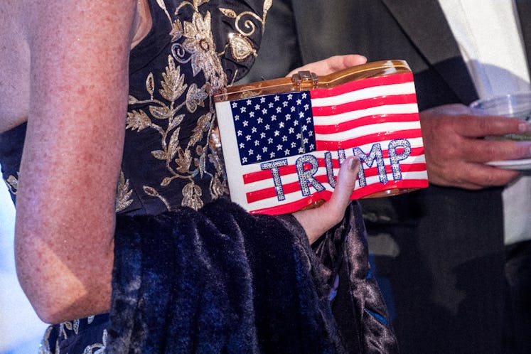 A woman holding a purse with the flag of the United States and 'Trump' written on it