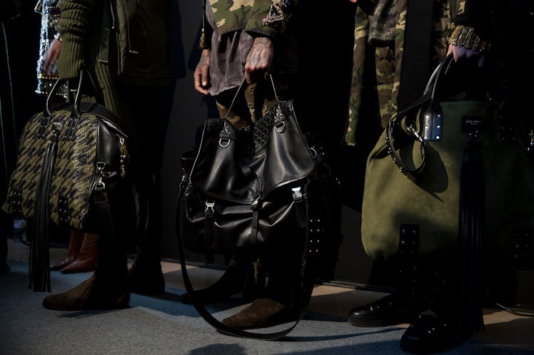 Models backstage holding Balmain Fall 2017 handbags.