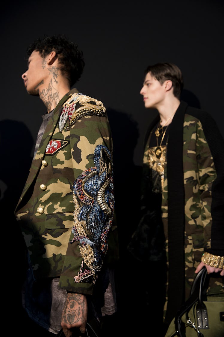 Models in camouflage looks backstage at Balmain Men’s Fall 2017.