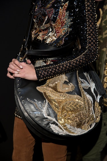 A model wearing Balmain Fall 2017 sequined dress and a bag.