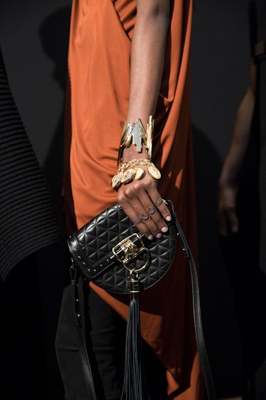 A model in an orange dress holding Balmain Fall 2017 bag.