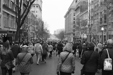 A semi-aerial view of people walking down a street at the Women's March in Washington D.C.