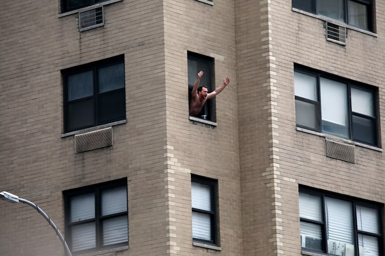 A man looking through a window of a building and waving at the New York City Women's March