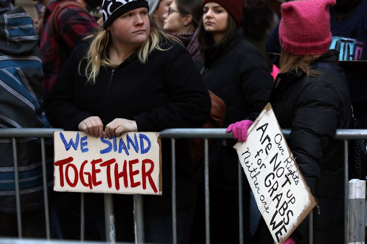 Two women holding a 'We stand together' and 'Our rights are not for  grabs neither are we' at the Ne...
