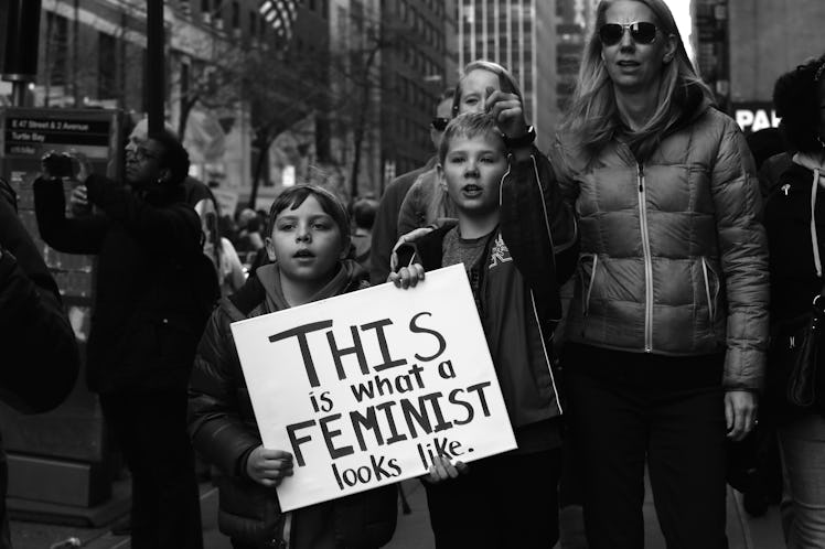Two women and two children holding the poster 'This is what a feminist looks like.'