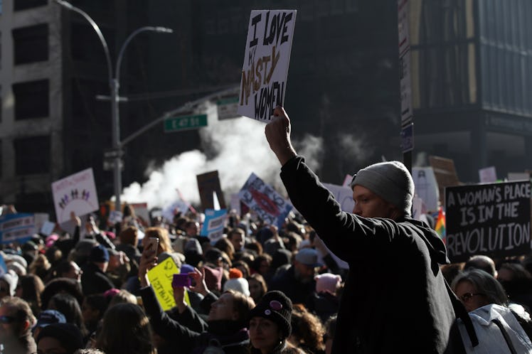 A large crowd gathered and holding protest posters and signs at the New York City Women's March