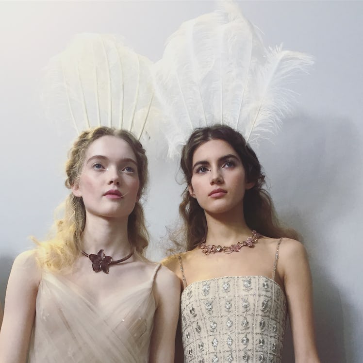 Two models with feather crowns during Christian Dior Haute Couture Spring 2017 show.