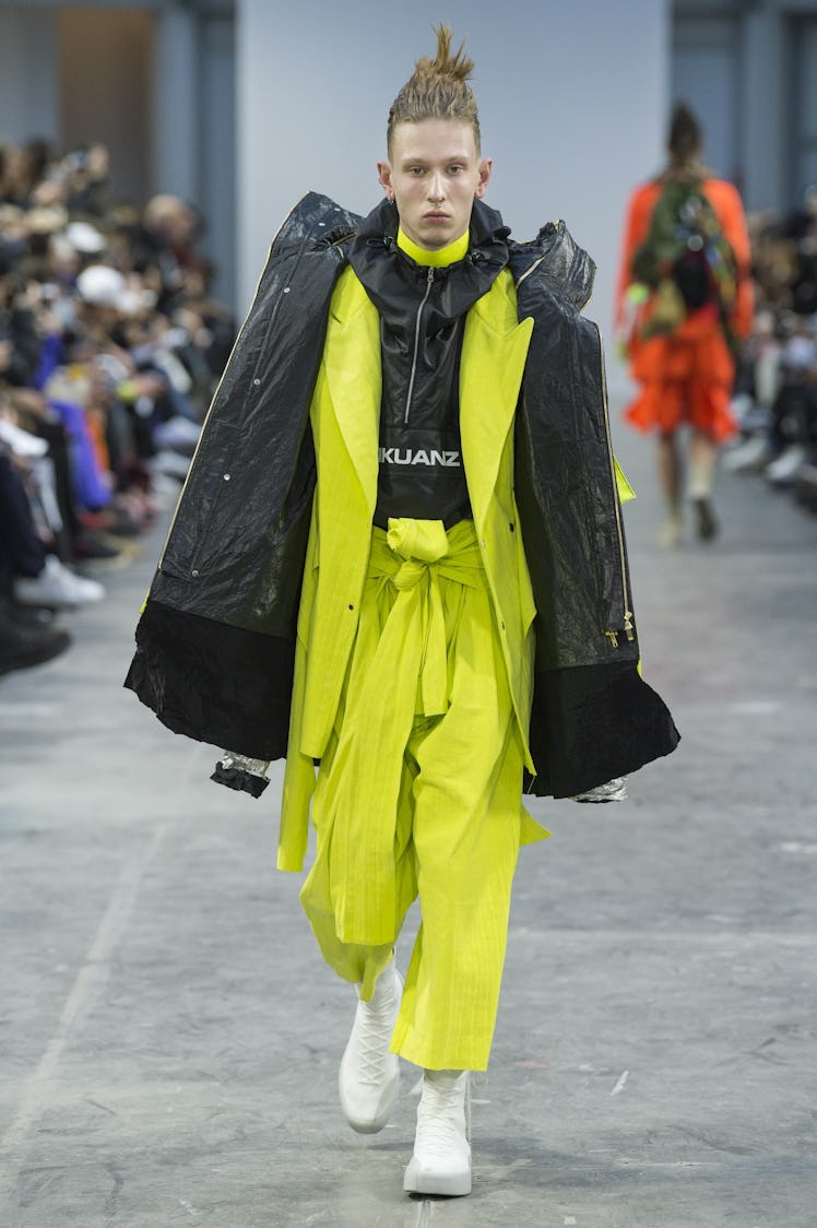 A model wearing lime green pants with a black and lime green jacket at the Sankuanz Fall 2017 runway
