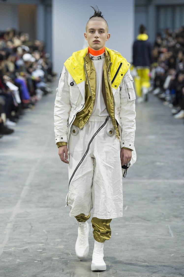A model wearing white and gold pants and jacket combination at the Sankuanz Fall 2017 runway