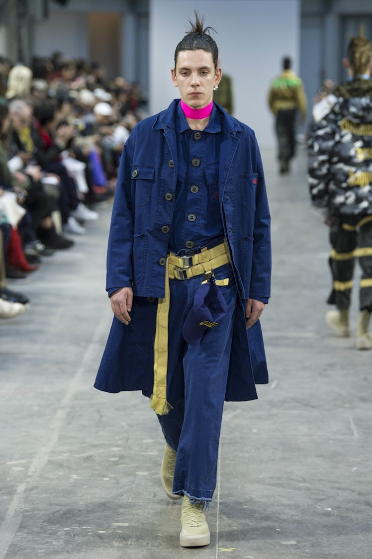 A model wearing blue pants and a blue jacket with a pink choker at the Sankuanz Fall 2017 runway