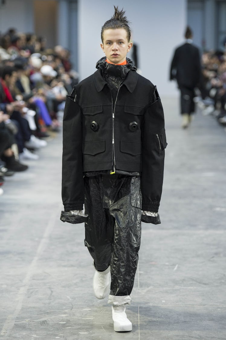 A model wearing a black jumpsuit with an oversized black jacket at the Sankuanz Fall 2017 runway