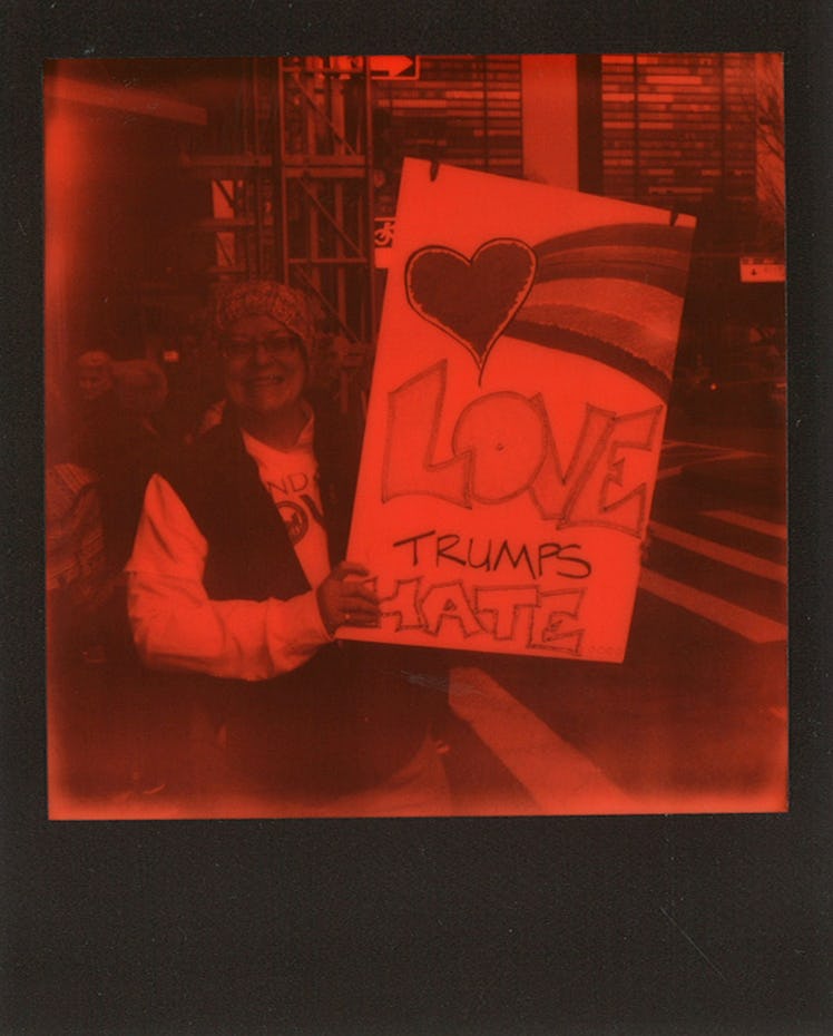 A woman holding a poster with "LOVE TRUMPS HATE" text at the Women’s March in NYC