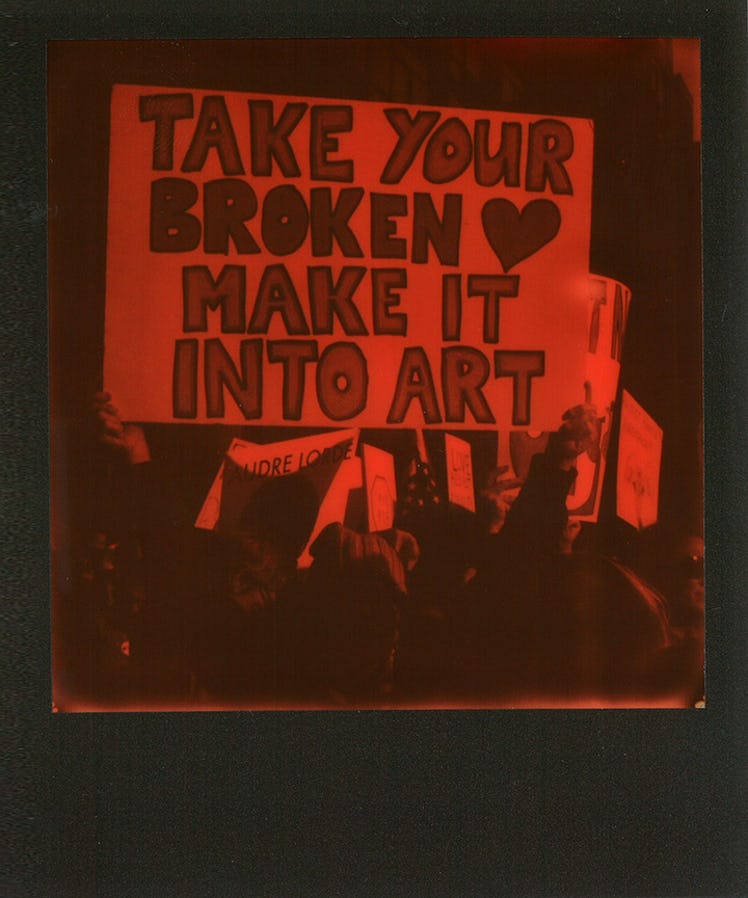 A poster with "TAKE YOUR BROKEN HEART MAKE IT INTO ART" text at the Women’s March in NYC