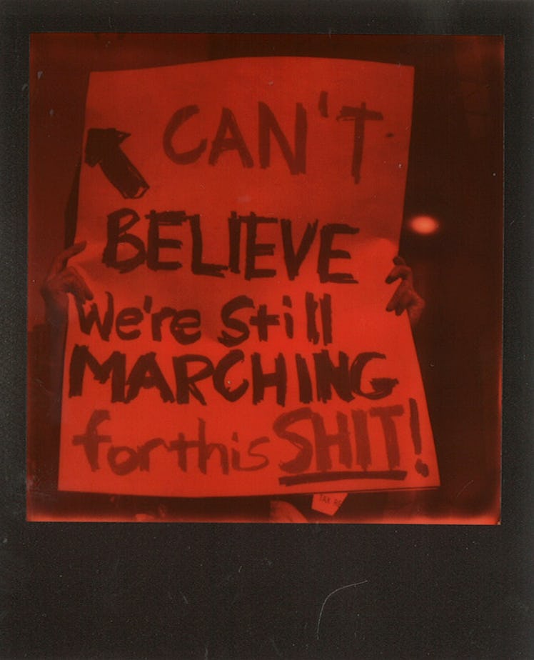 A poster with "CAN'T BELIEVE We're Still MARCHING for this SHIT" text at the Women’s March in NYC
